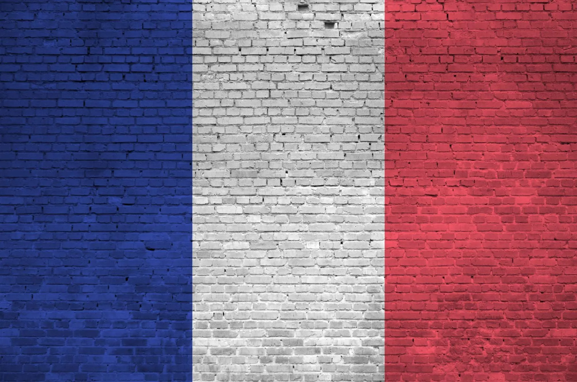 France flag depicted in paint colors on old brick wall close up